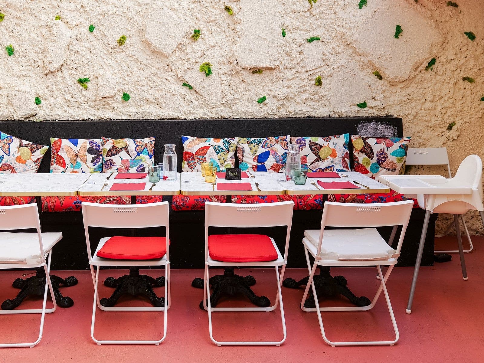 La véranda de Peach Strasbourg : voûte en pierre, banquette papillons, tables marbre